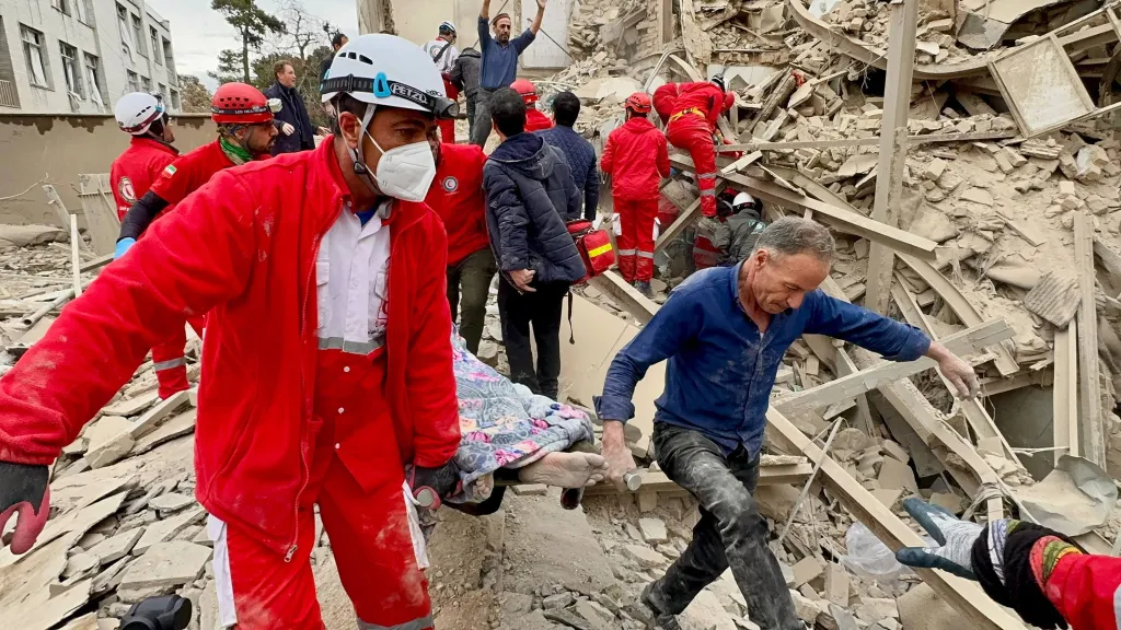 Rescue workers carry an injured man on a stretcher after an airstrike in Tehran, Iran.