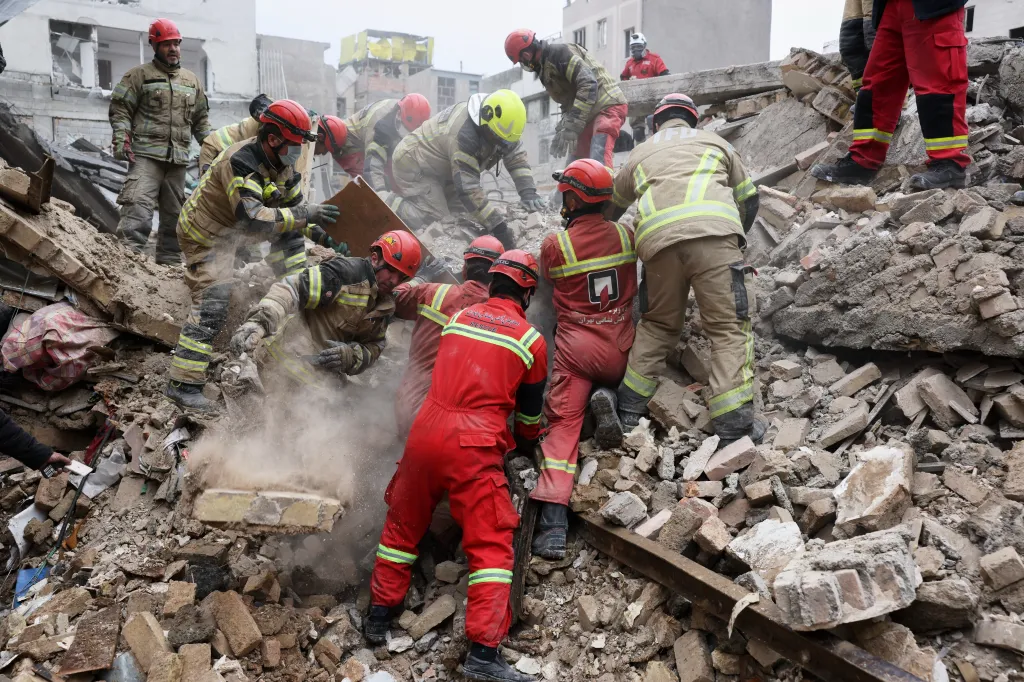 Rescue workers searching for survivors in rubble after a strike in southern Tehran, Iran.