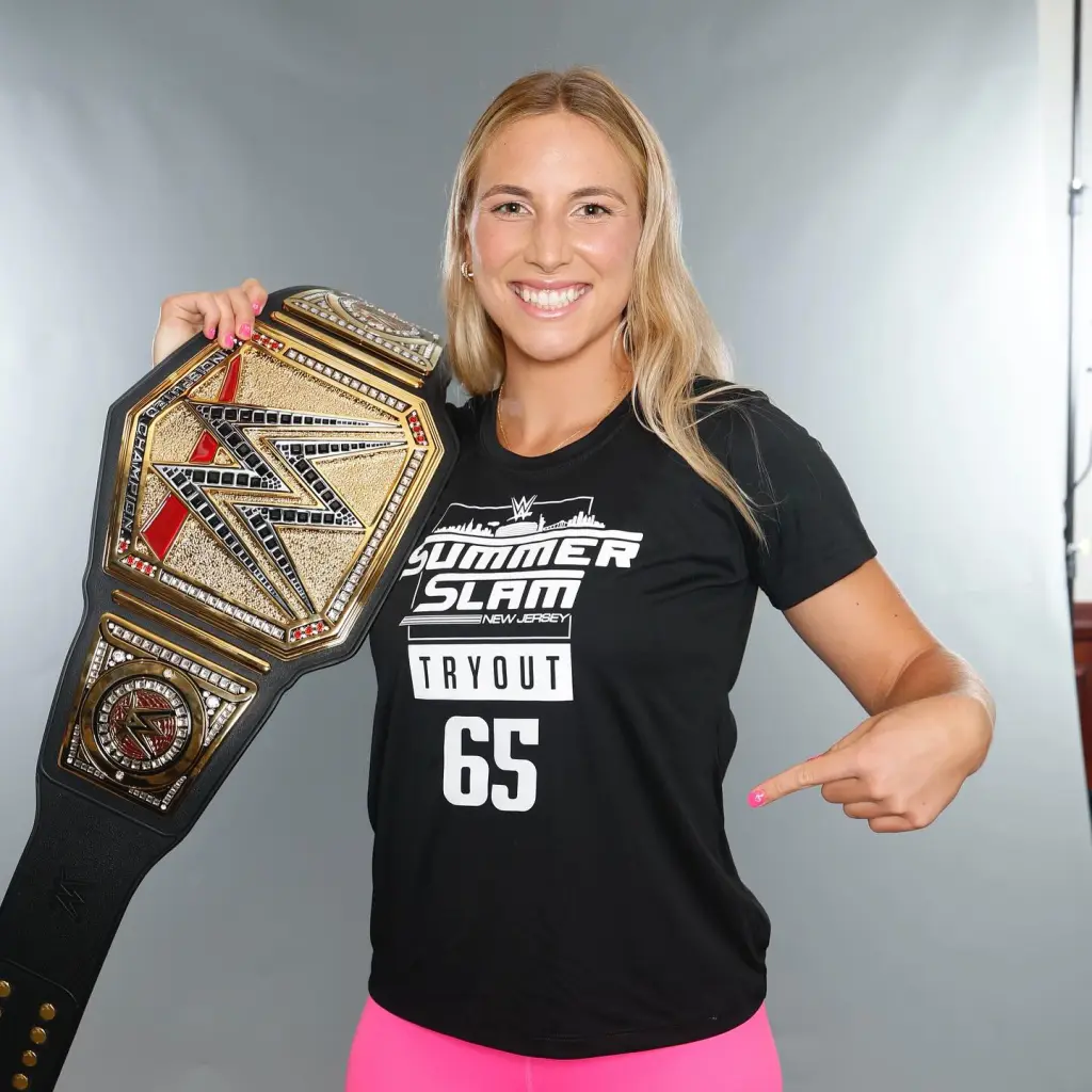 Zoe Hines holding a WWE championship belt.