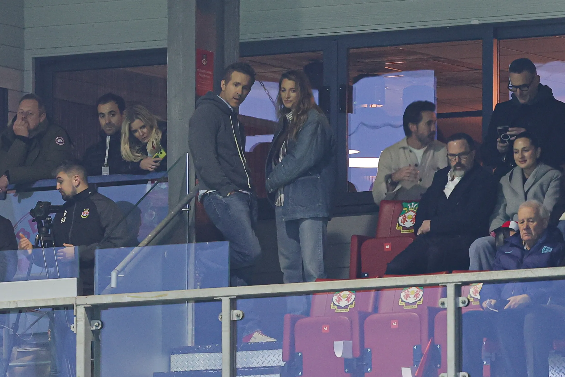 Ryan Reynolds and Blake Lively watching a soccer game from a stadium box.