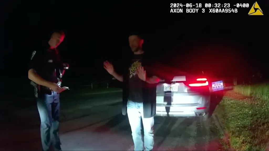 Bodycam footage of a police officer talking to Justin Timberlake next to a car at night.