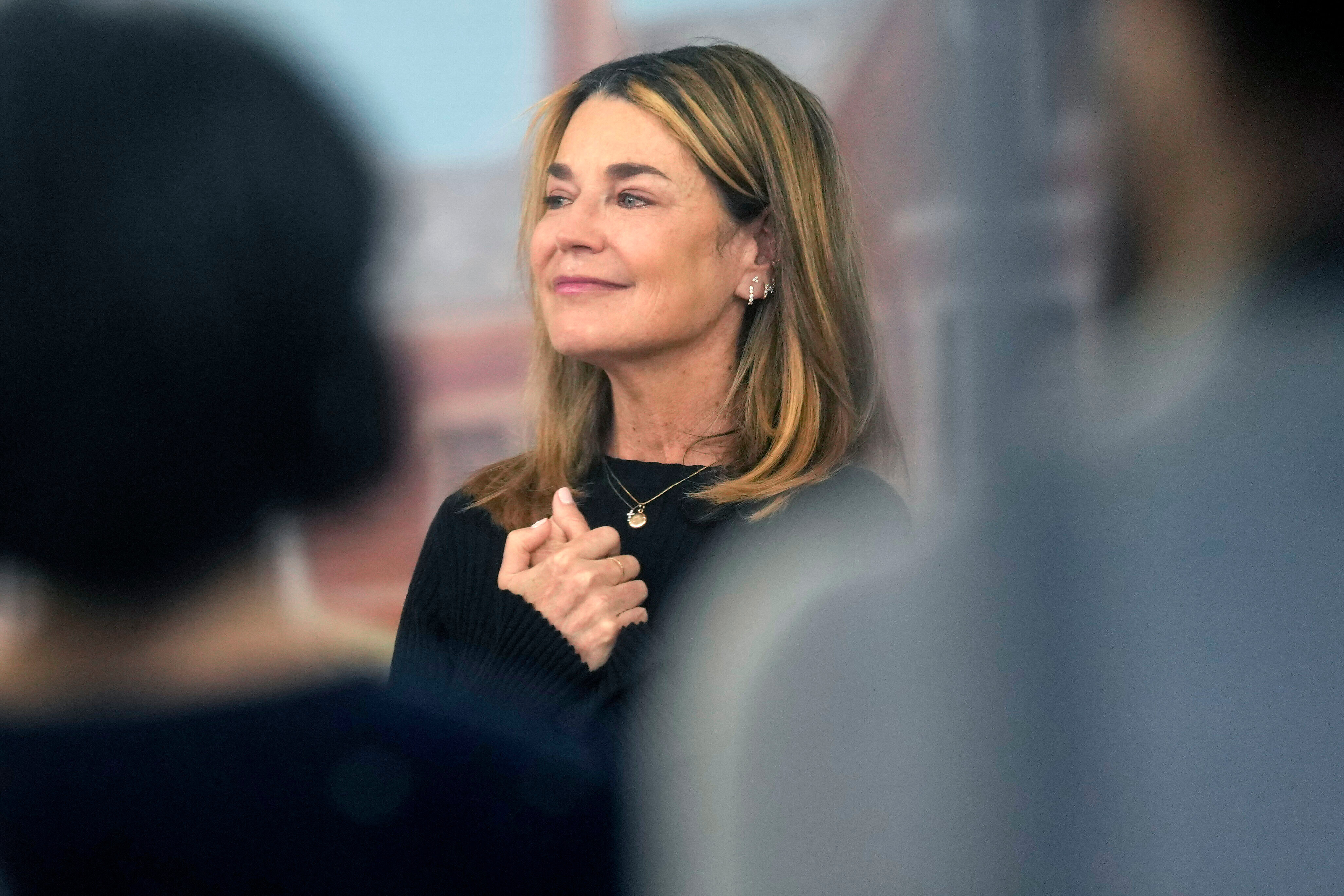 Savannah Guthrie, with light brown hair and a black top, poses with her hands clasped.