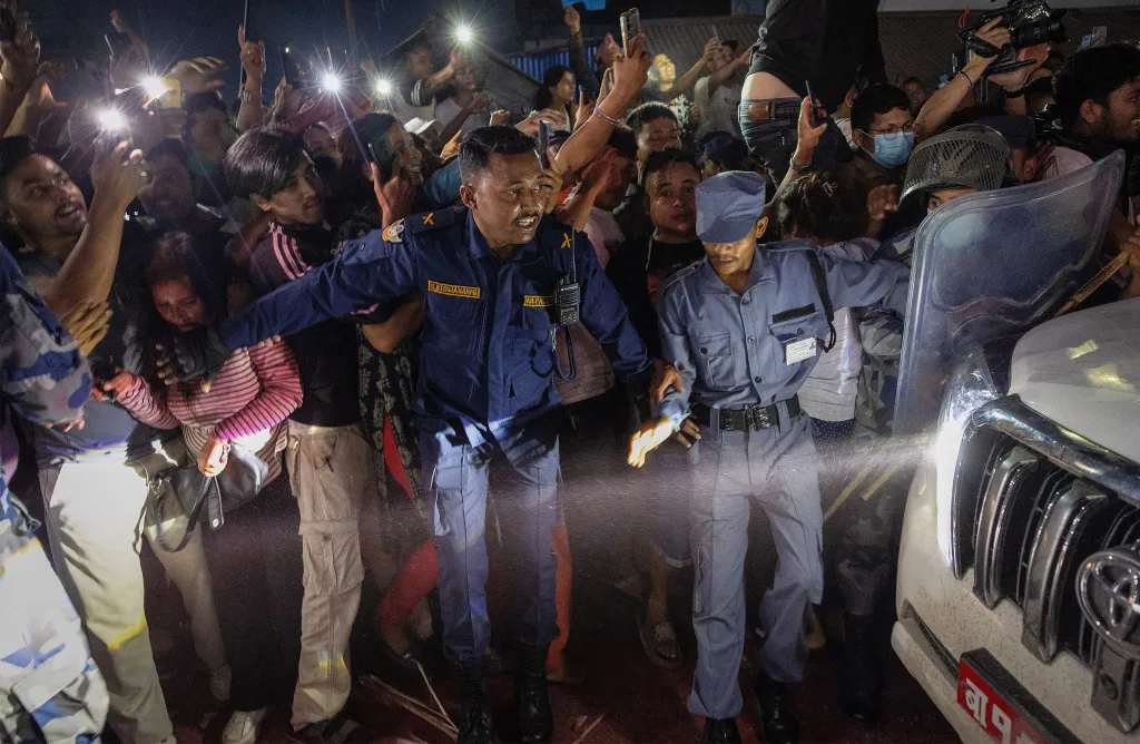 Security personnel control celebrating supporters of Balendra Shah after his election win in Damak, Nepal.