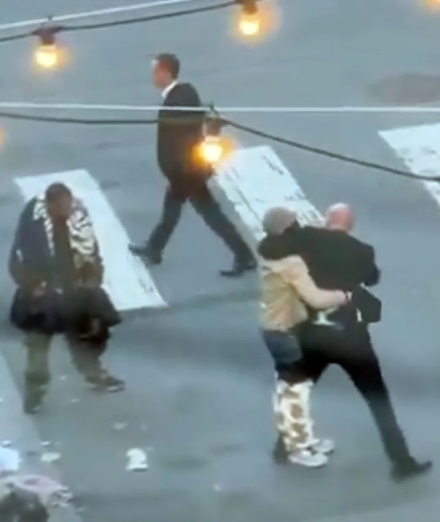 Daniel Lurie walking away from an altercation where a man is holding another man, and a third person is sitting on the ground.