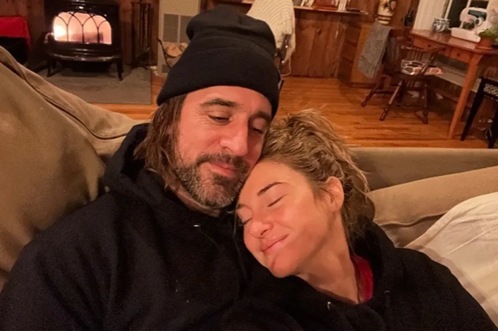 Aaron Rodgers and Shailene Woodley relaxing together on a couch, with Woodley resting her head on Rodgers' shoulder.
