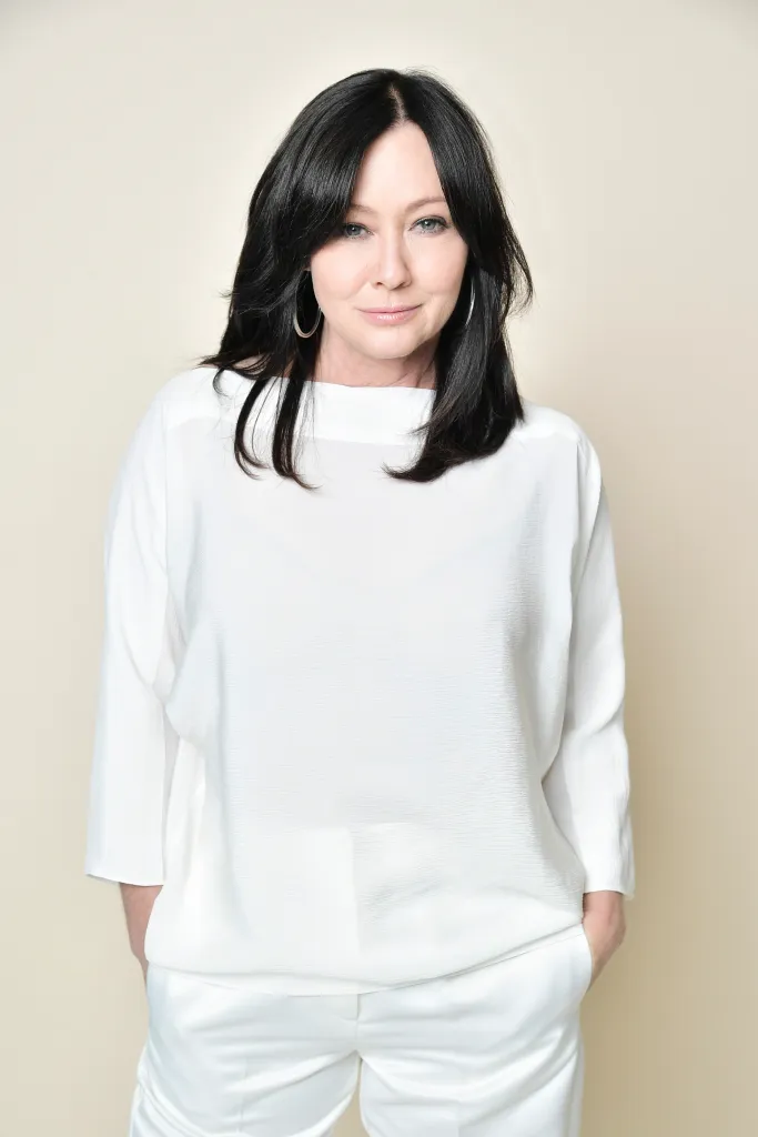 Shannen Doherty in a white outfit, posing for a portrait.