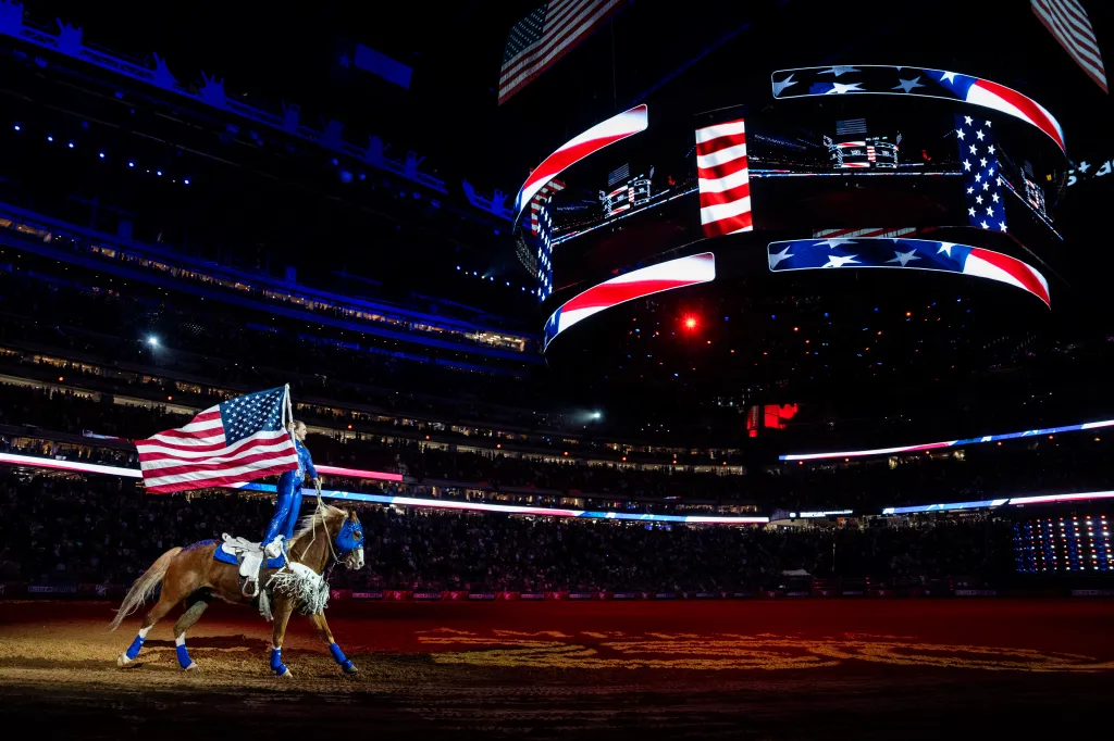 Shelby Pierson carries an American flag on horseback at the Houston Livestock Show and Rodeo.