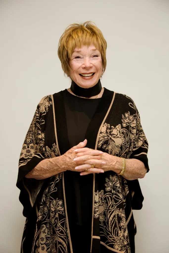 Shirley MacLaine laughing at a press conference.