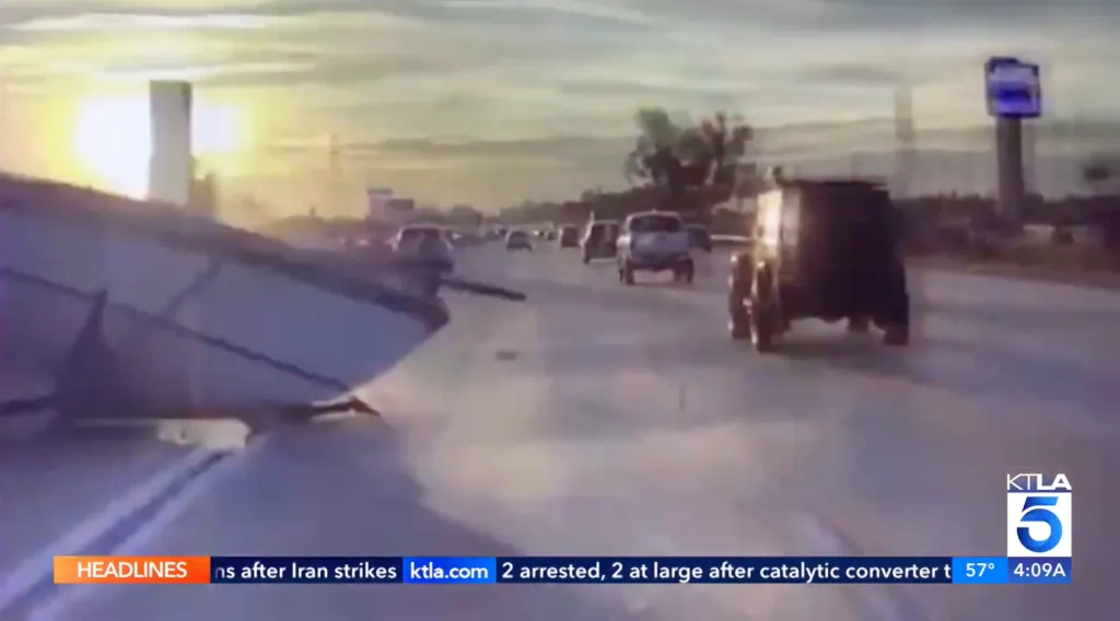 A boat flies over a freeway median, landing in oncoming traffic.