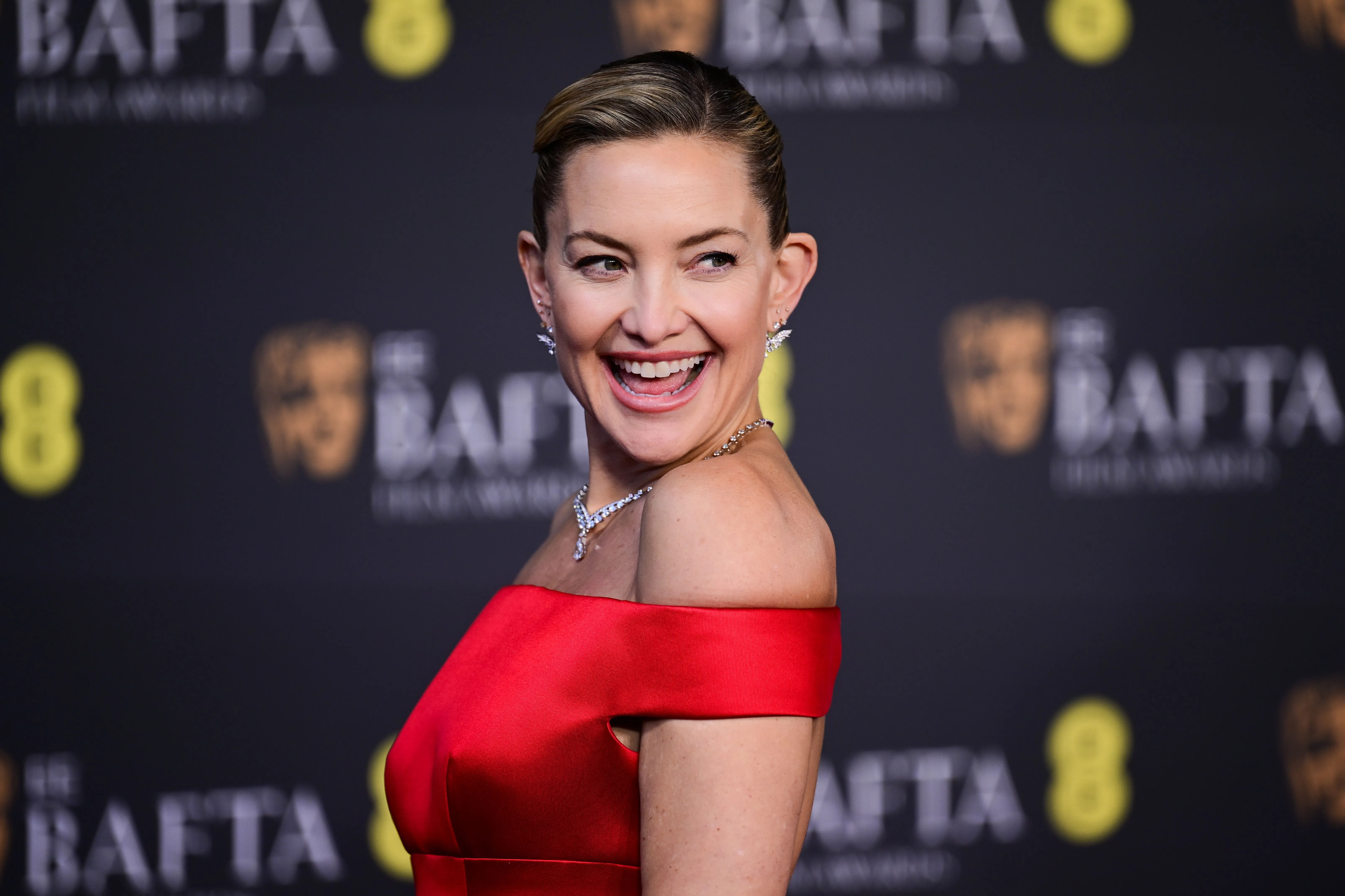Kate Hudson smiling at the 79th BAFTA British Academy Film Awards.