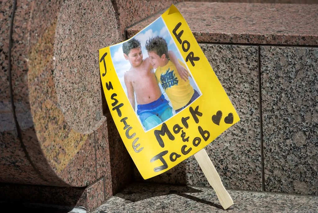 A sign showing a photo of Mark Iskander, 11, and his brother Jacob Iskander, 8, with 