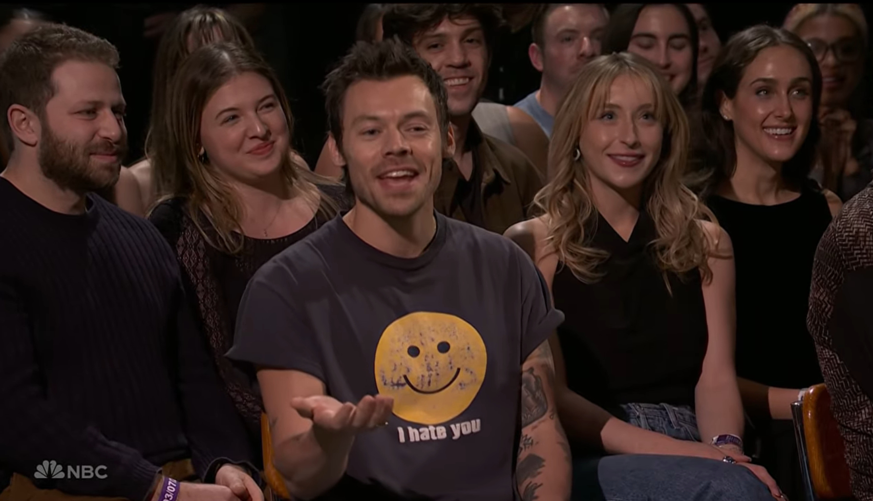 Harry Styles in a black t-shirt with a yellow 