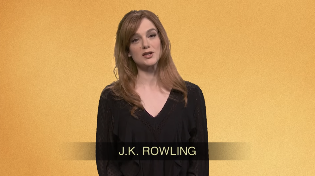 A woman with long light brown hair and a black top stands against a yellow background with 