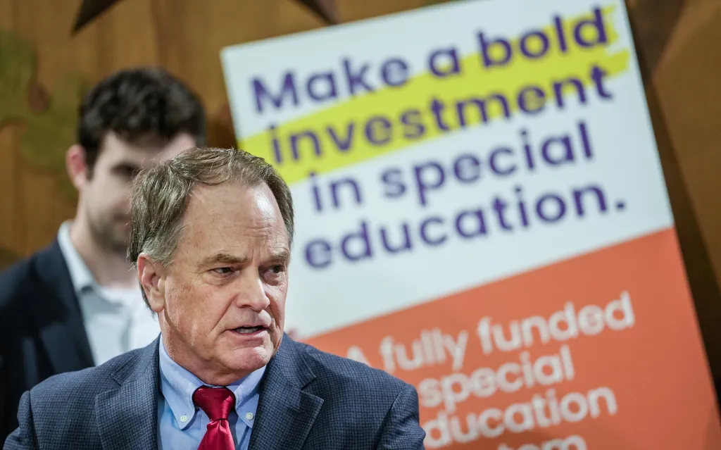 State Representative Steve Toth speaks in front of a sign advocating for investment in special education.