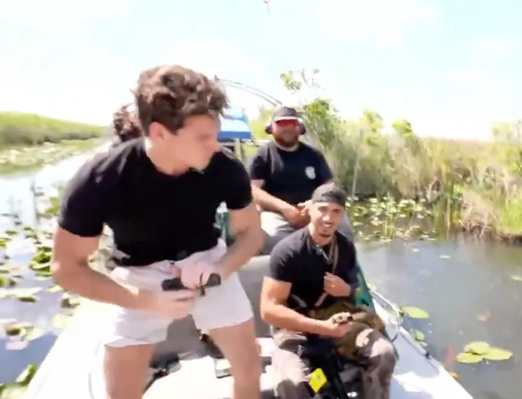 Video still of a streamer holding a handgun in an airboat on the Florida Everglades.