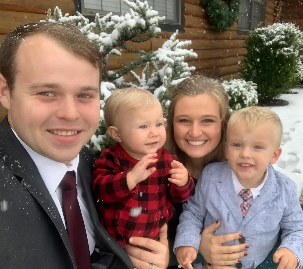 A family of four, including Joseph and Kendra Duggar, poses for a photo in the snow.
