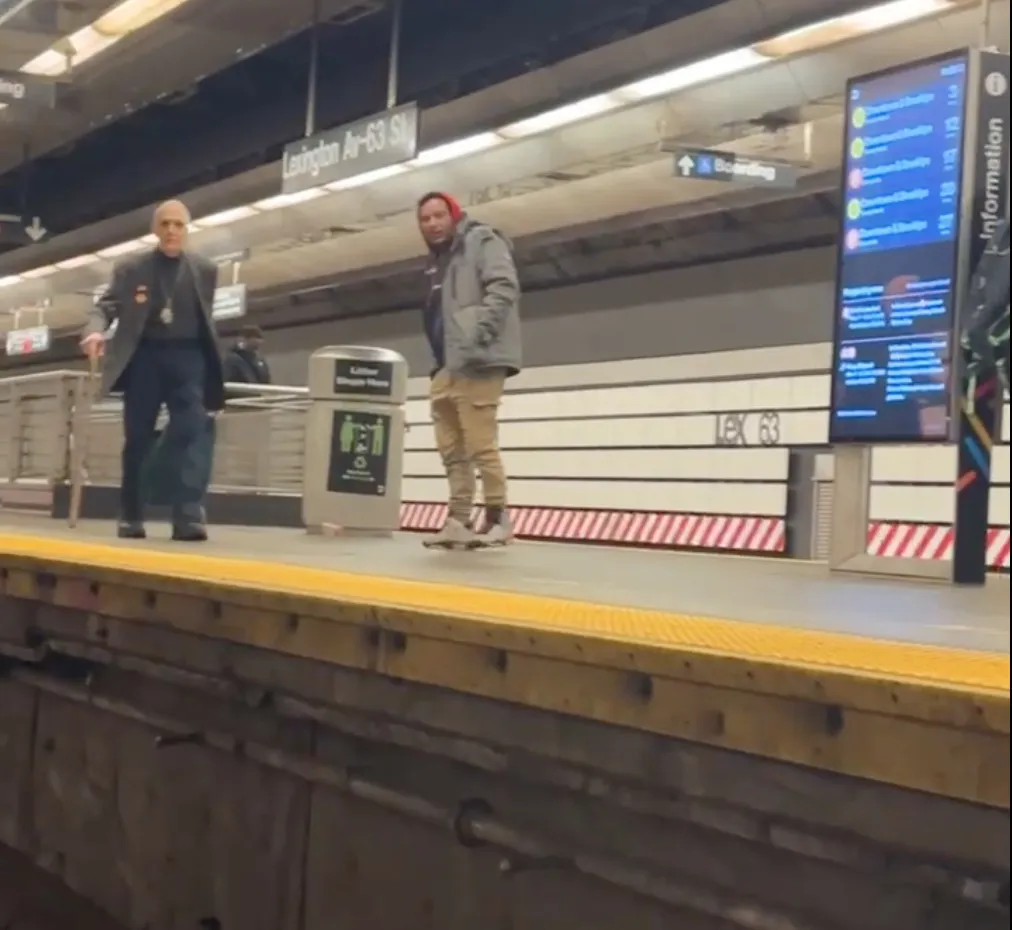 Suspect Bairon Hernandez on a subway platform with an elderly man.