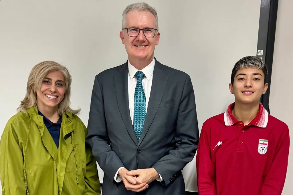 Australia's Home Affairs Minister Tony Burke (center) with an Iranian football player (right) and team official (left) in Sydney.
