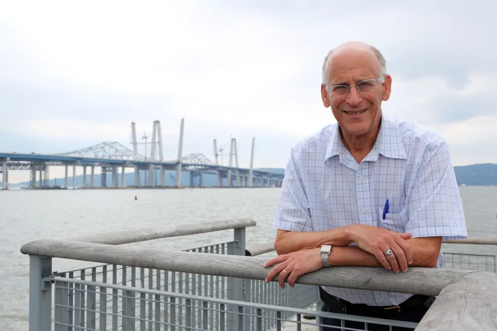 Greenburgh Town Supervisor Paul Feiner stands by the water with a bridge in the background.