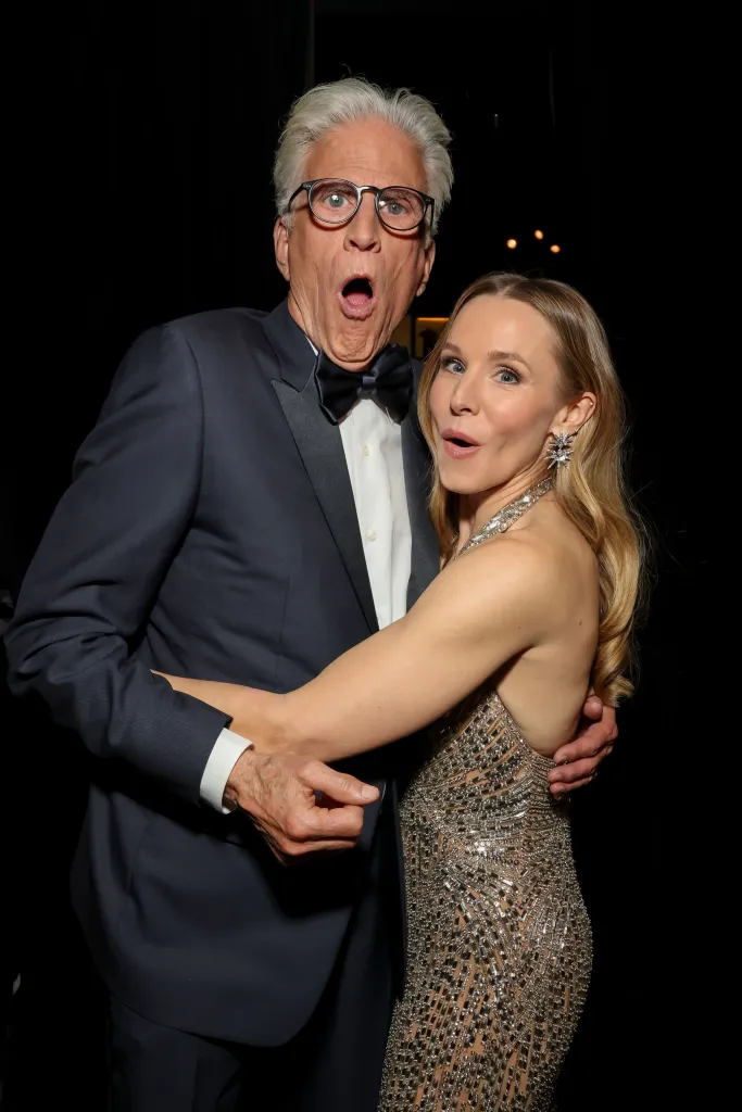 Ted Danson and Kristen Bell making funny faces while posing for a photo.