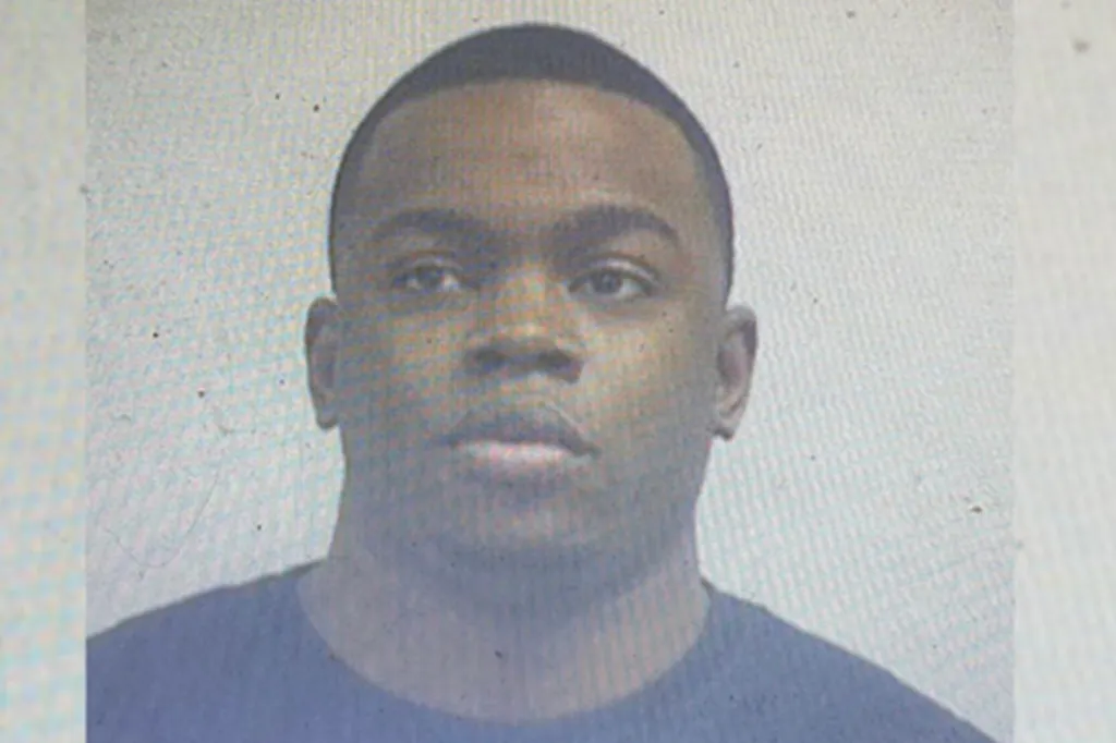 Mugshot of a young Black man looking directly at the camera.
