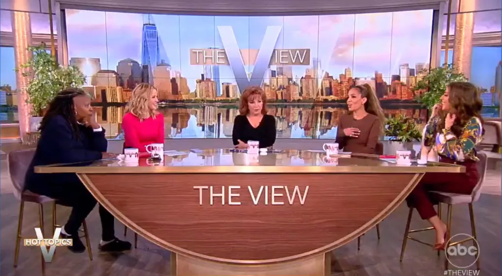 Five women sitting at a desk with 
