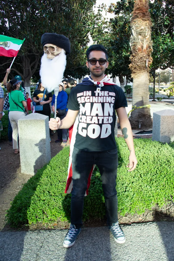 A person at a protest wearing a T-shirt that says, 