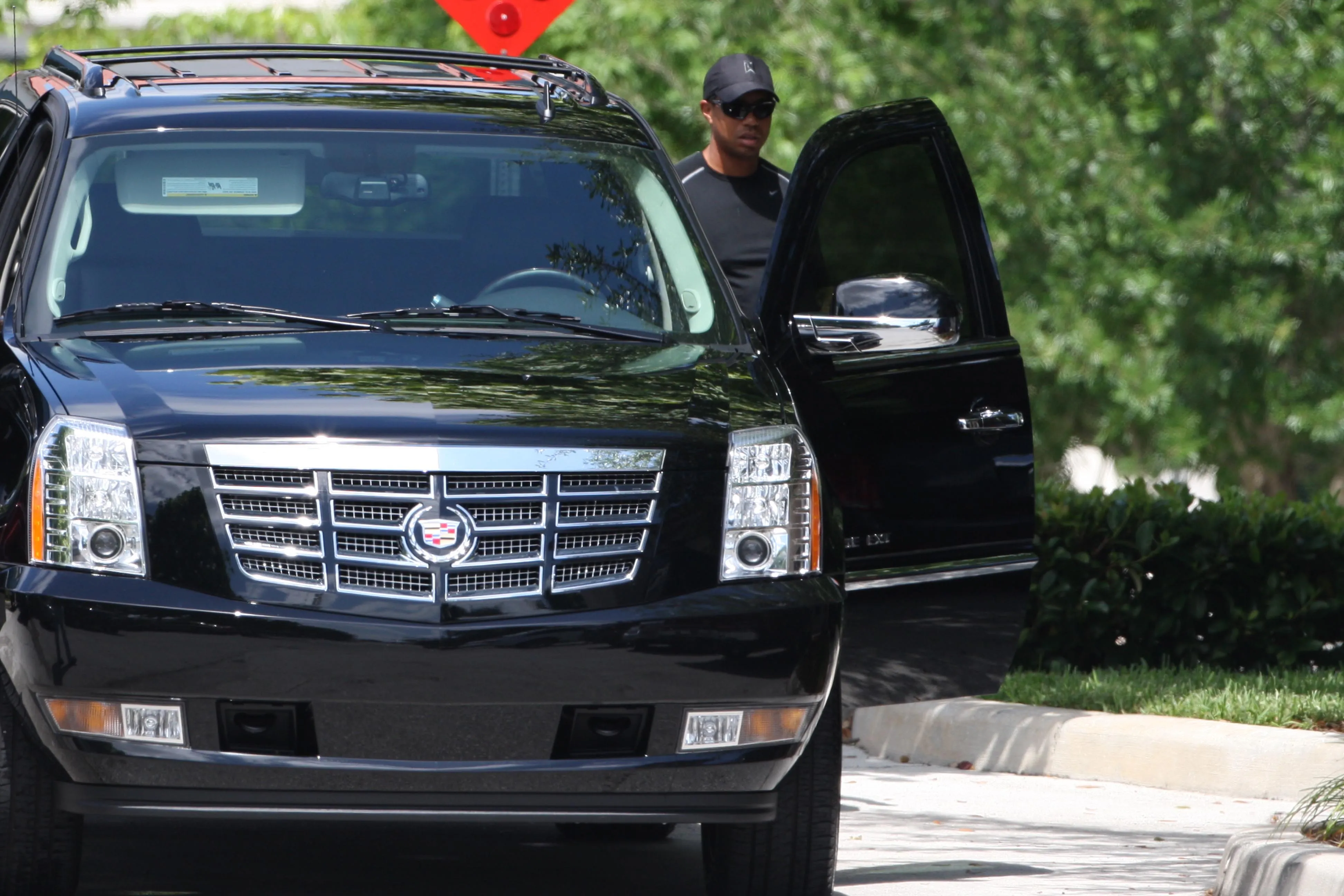 Tiger Woods getting out of a black SUV.