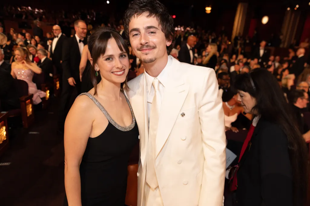 Timothée Chalamet and a female companion pose for a photo at the 98th Academy Awards.