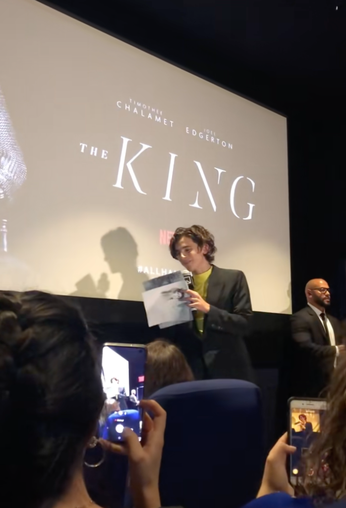 Timothée Chalamet speaking in front of a screen displaying 