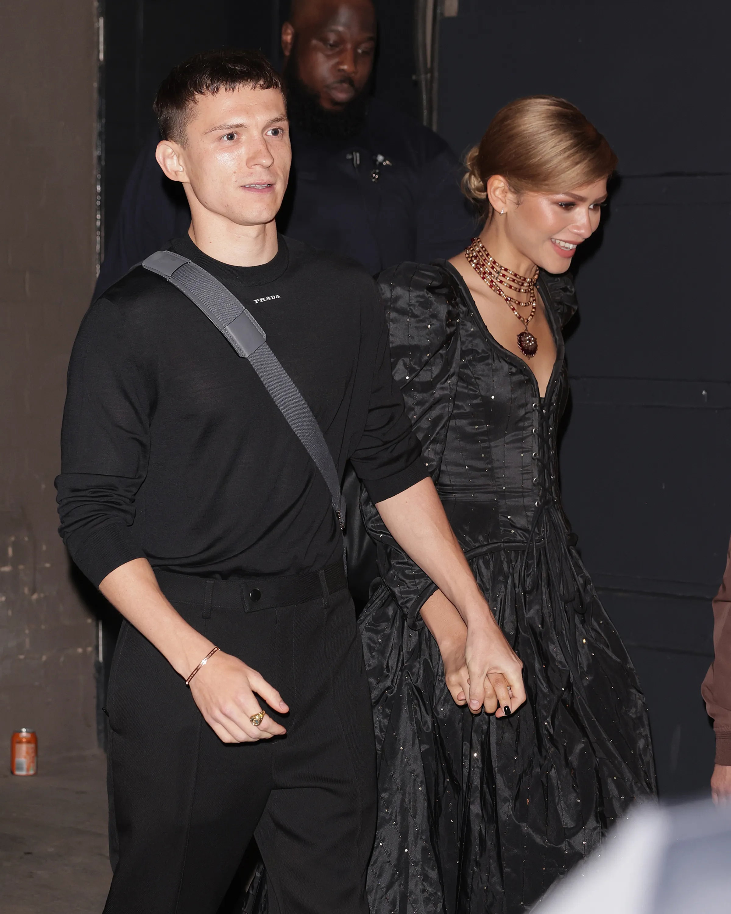Tom Holland and Zendaya holding hands while leaving The Duke of York's Theatre.