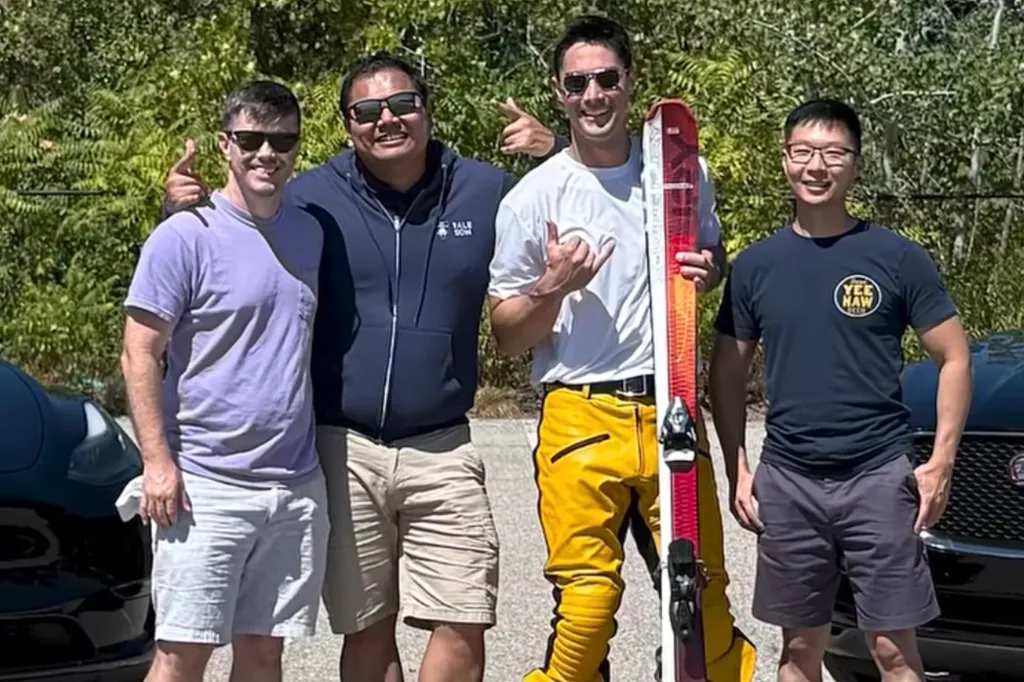 Four men, including record breaker Johnny Cruz Buckingham (second from right) holding a ski, smiling at the camera.
