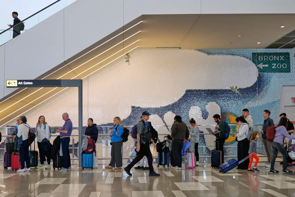 Travelers wait in lines for security at LaGuardia Airport.