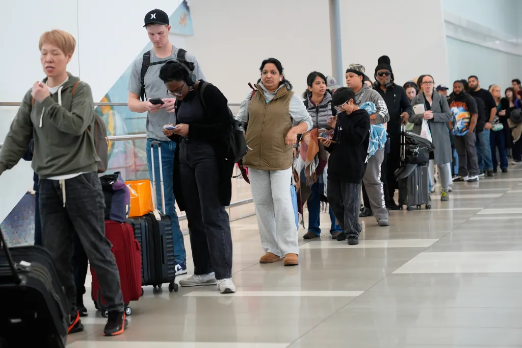 Travelers wait in a line to get through security at LaGuardia Airport.