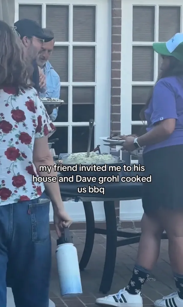 Dave Grohl serving coleslaw and BBQ at a backyard party.