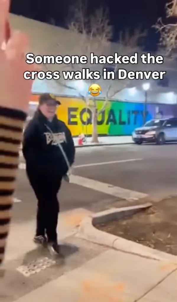 Video of someone crossing a street with a rainbow 