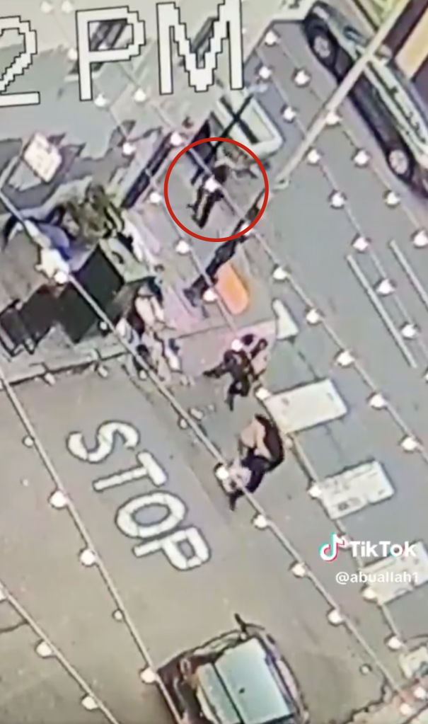 CCTV footage showing two men attacking a police officer, highlighted by a red circle, with other figures and a car on the street.