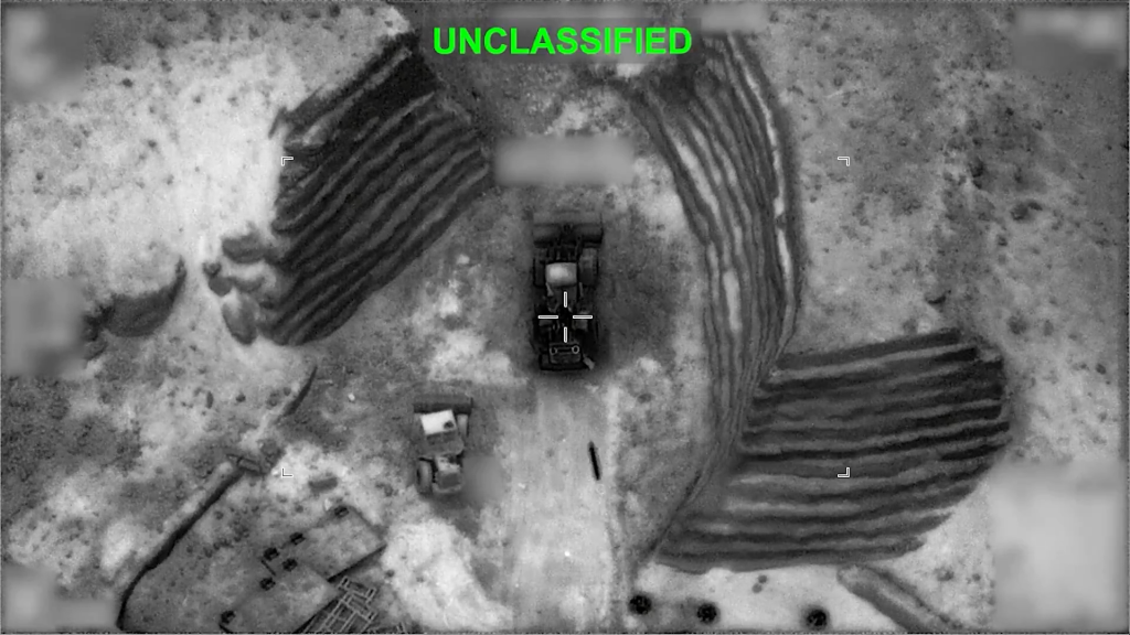 Overhead view of two bulldozers near fortified earthworks, with a targeting reticle on one vehicle.