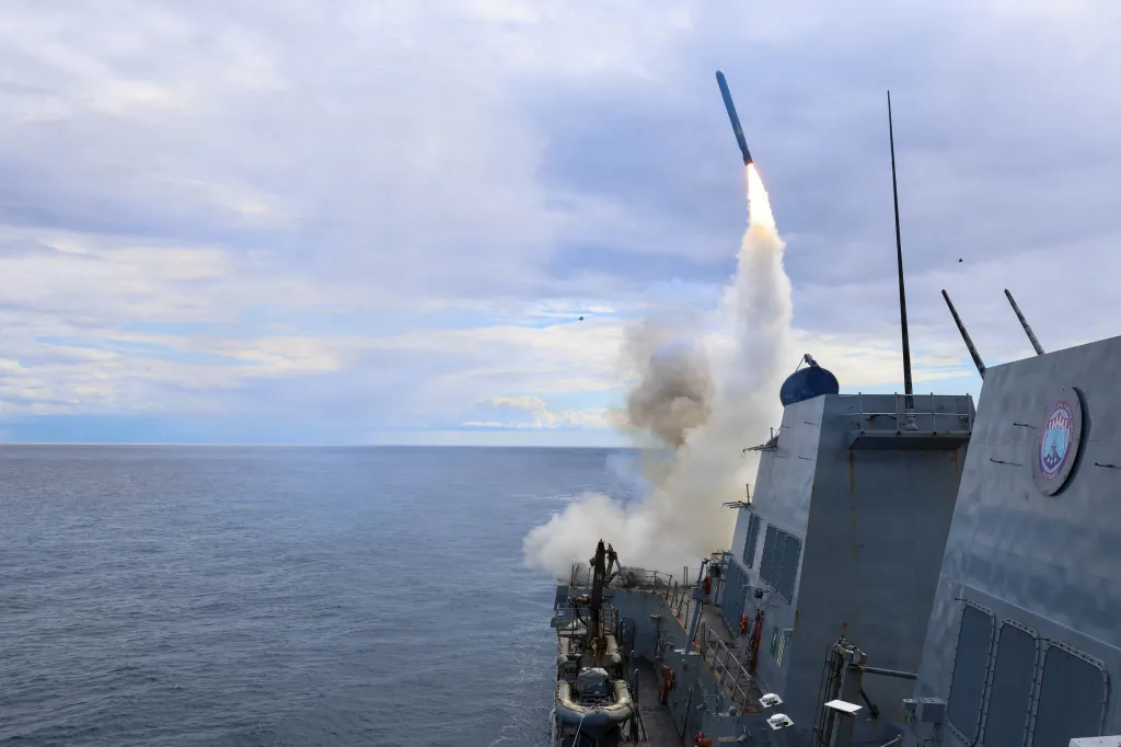 The USS Thomas Hudner firing a Tomahawk land attack missile at sea.