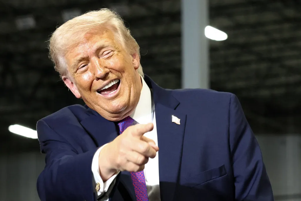 Donald Trump laughs while pointing.