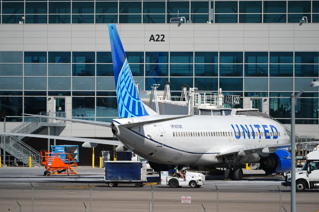 A United Airlines jetliner parked at gate A22 at Denver International Airport.