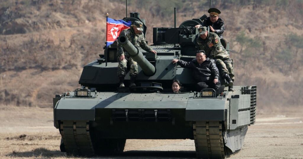 Teen daughter of North Korean leader Kim drives a tank while observing drill with her father