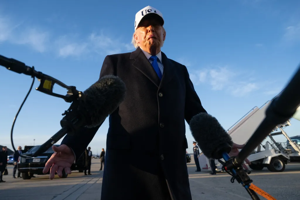 Donald Trump speaks to reporters in front of Air Force One, wearing a 