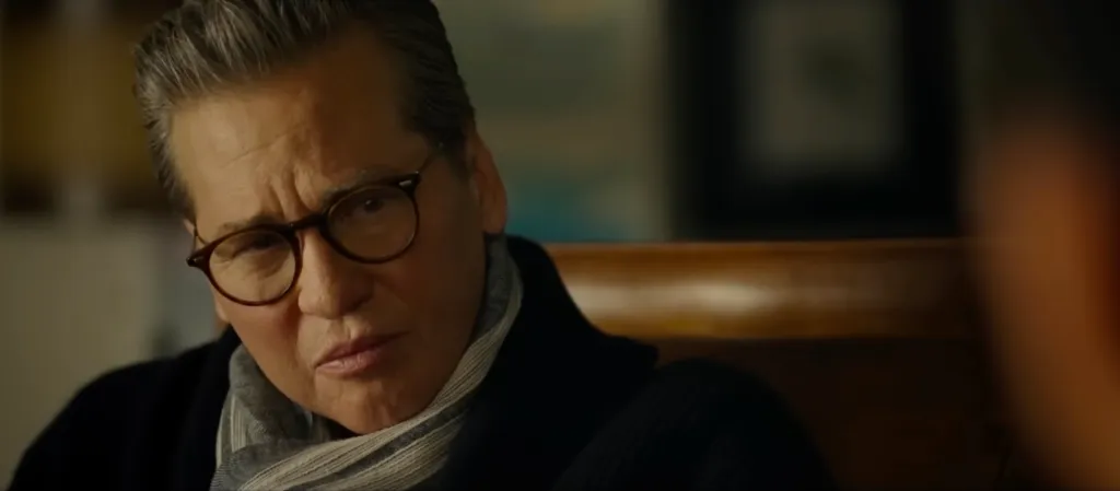 Val Kilmer as Iceman in Top Gun: Maverick wearing glasses and a striped scarf.