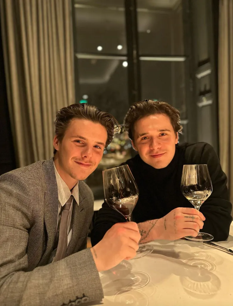Brooklyn and Cruz Beckham holding wine glasses at a restaurant.
