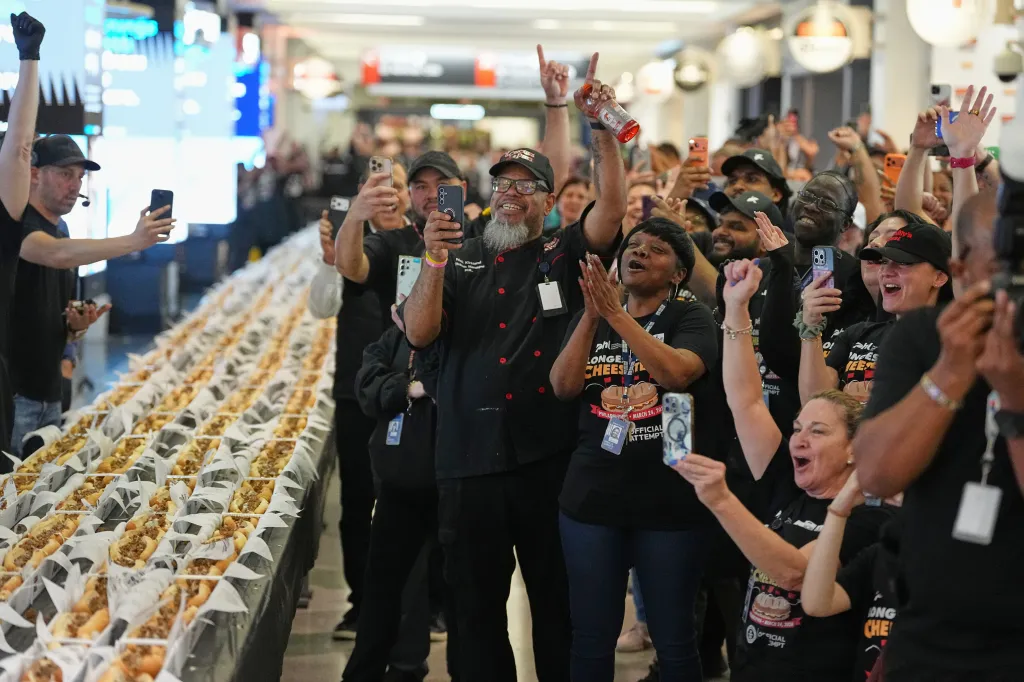 Volunteers cheering for the longest cheesesteak at Philadelphia International Airport.