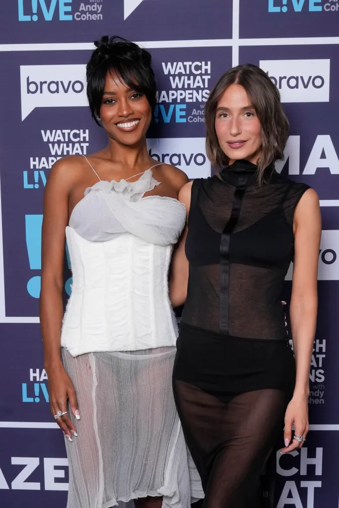 Ciara Miller and Amanda Batula standing together in front of a Bravo 