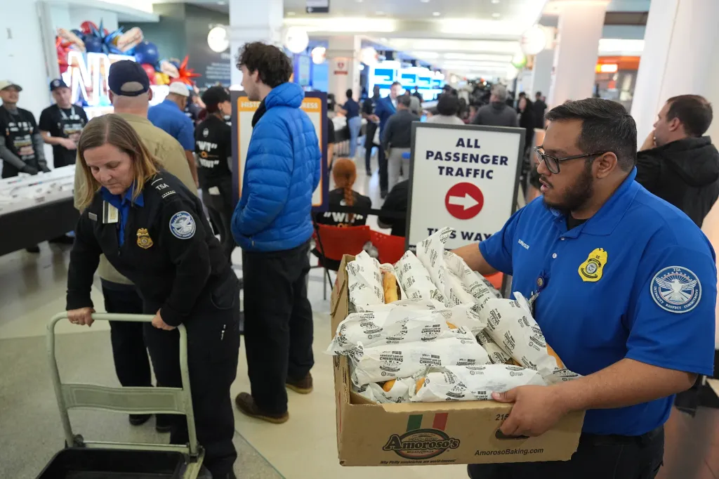 TSA employees carrying boxes of cheesesteaks at Philadelphia International Airport.