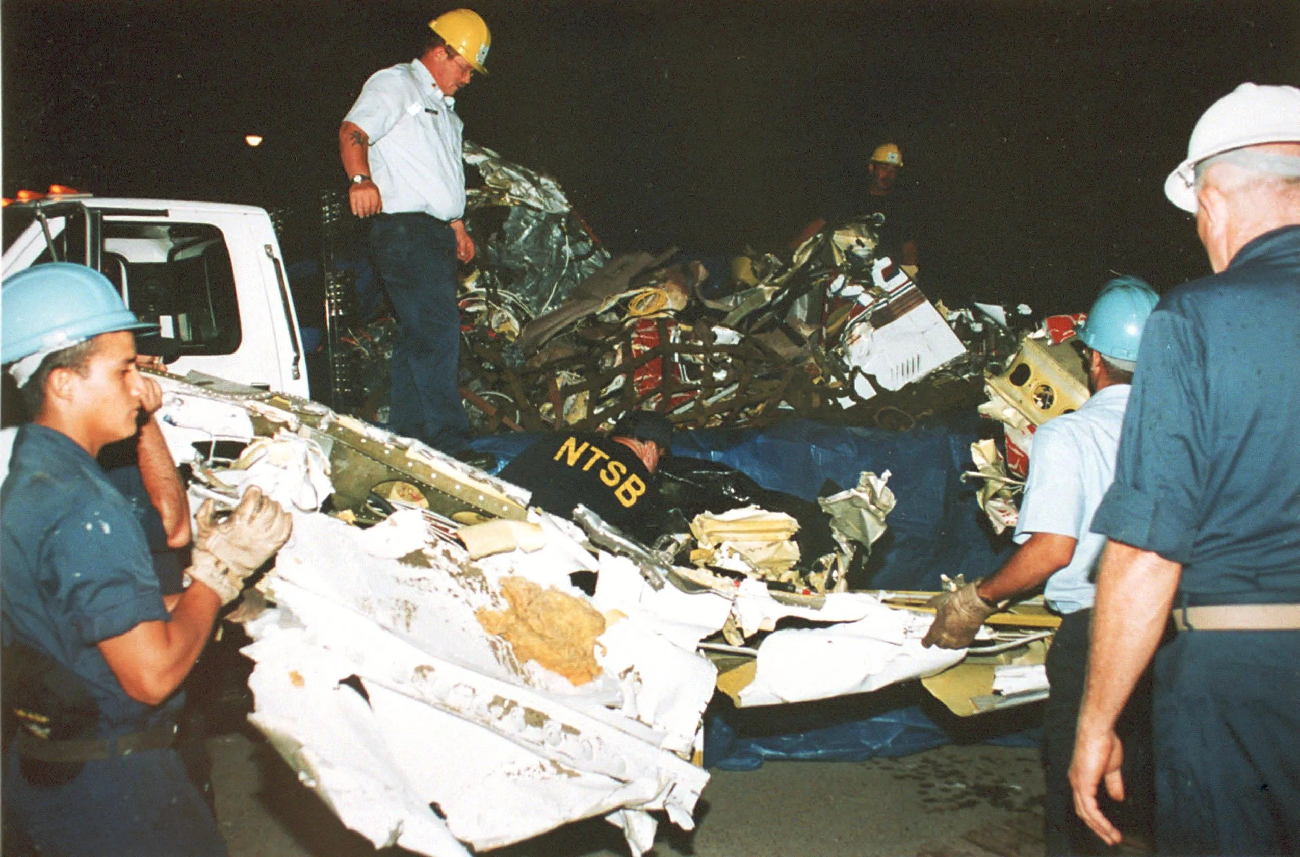 Workers retrieve wreckage of the Piper Saratoga II aircraft flown by John F. Kennedy Jr.