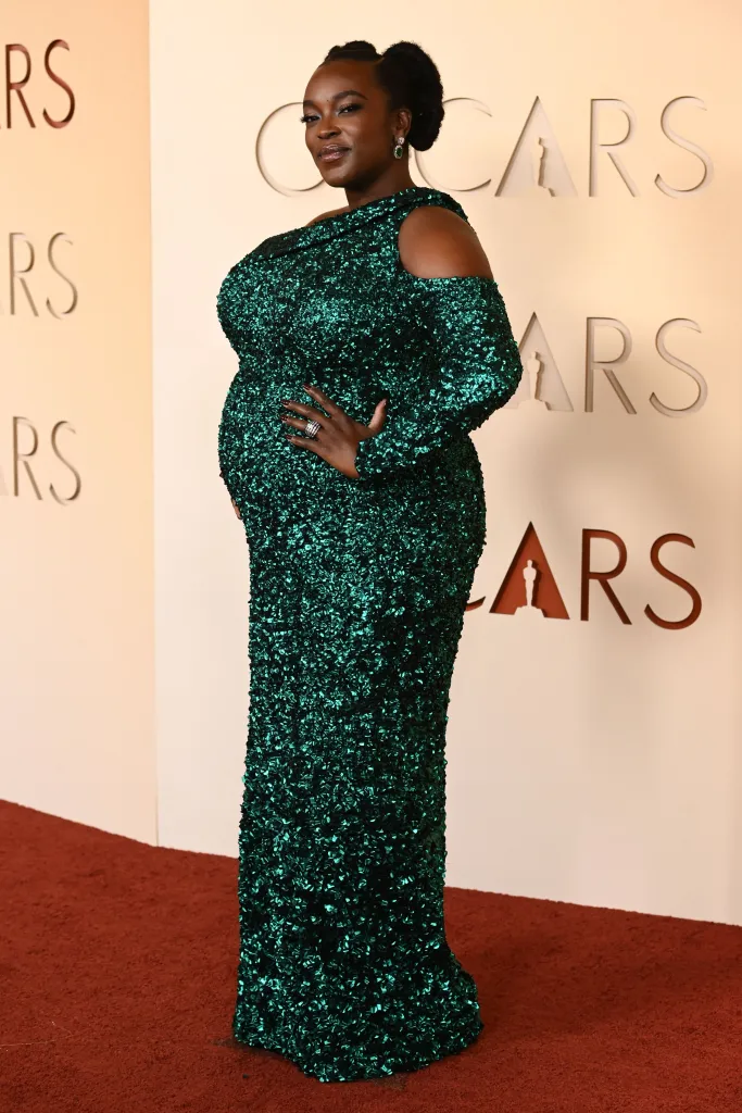 Wunmi Mosaku at the 98th Annual Academy Awards, wearing a long-sleeved, green sequined gown with a cold shoulder design.